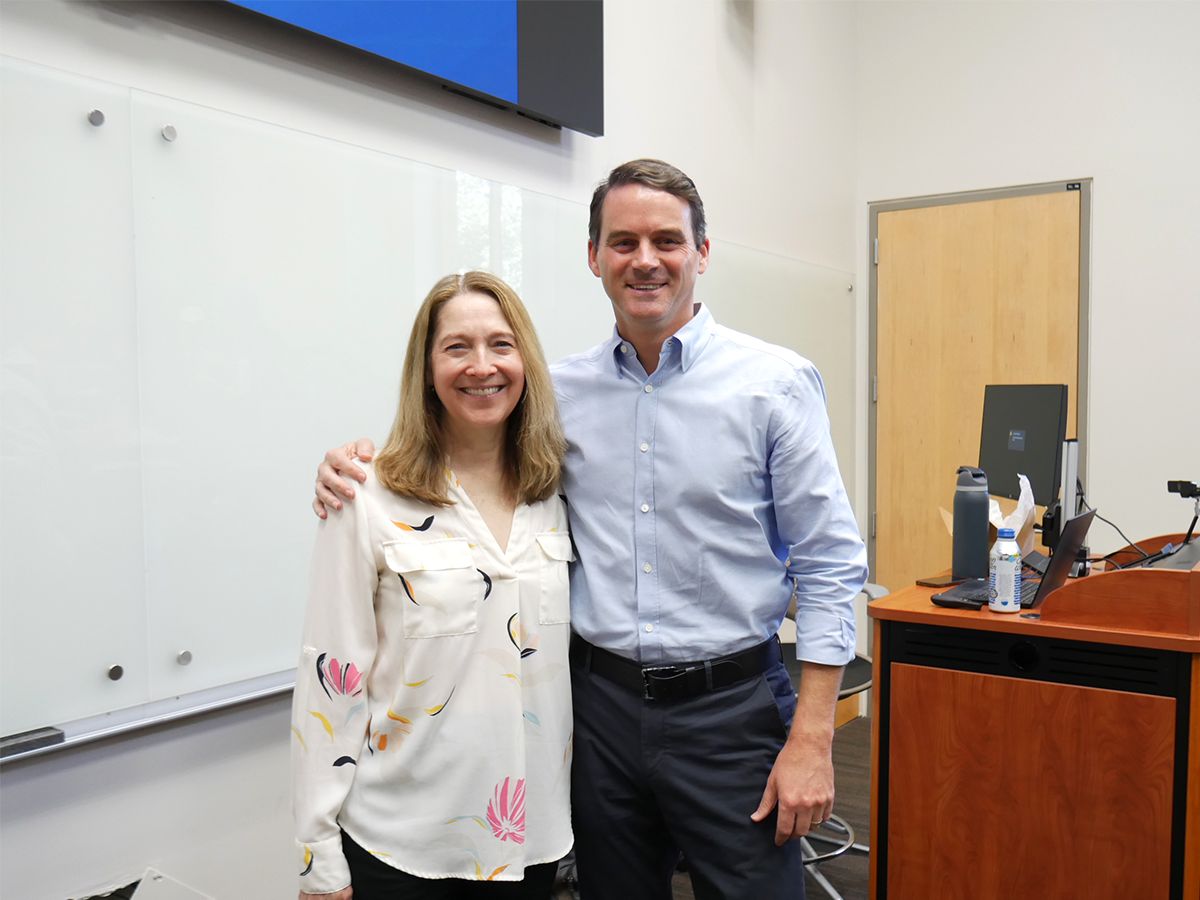 Michael Gazzano stands with Professor Mary Lynne Boorn while smiling for a photo.