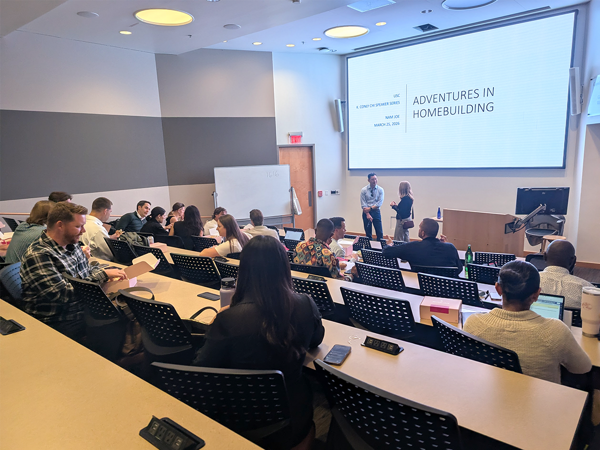 Photo: Students gather in a lecture hall as Nam Joe’s “Adventures in Homebuilding” presentation is displayed on screen during the Speaker Series.