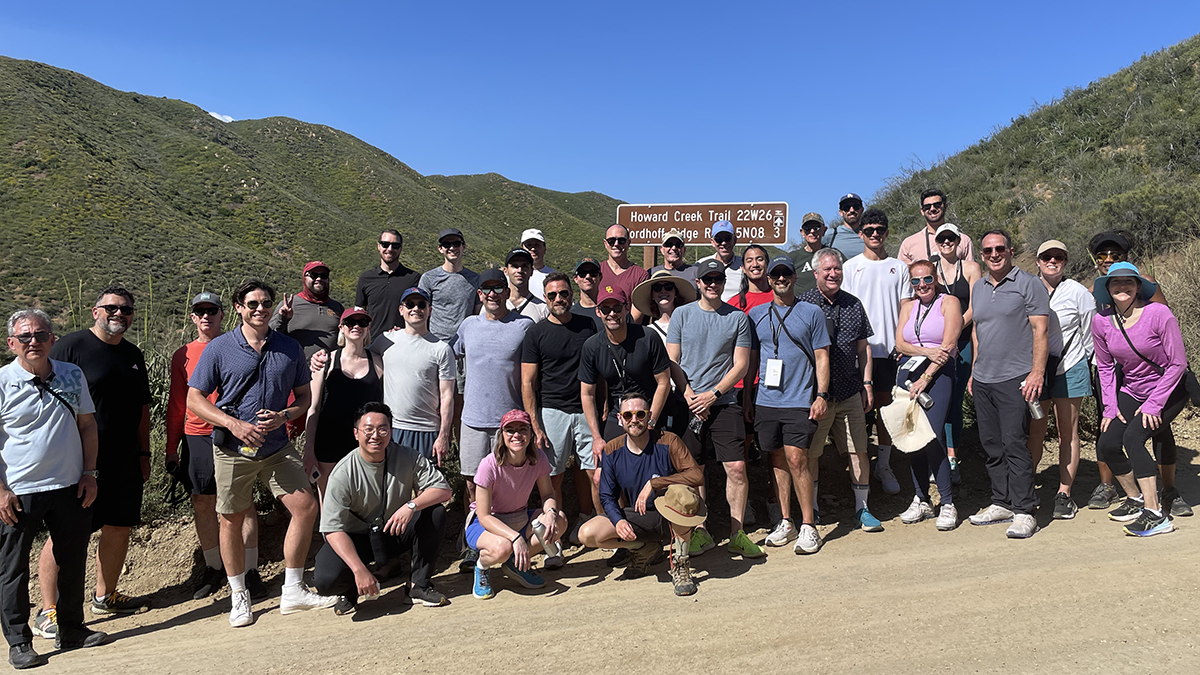 Photo: About 35 people stand at a trailhead for a photo